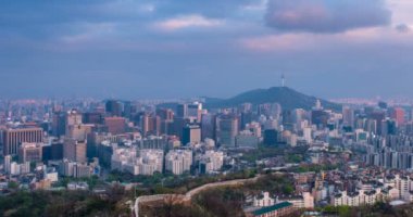 Seul şehir merkezi ve Inwang dağından Namsan Seul Kulesi 'ne gündüz ve gece geçişleriyle birlikte. Seul, Güney Kore. Yan hareket