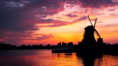 Hollanda 'nın ünlü turizm bölgesi Zaanse Schans' taki yel değirmenleri dramatik bir gökyüzü ile gün batımında. Zaandam, Hollanda