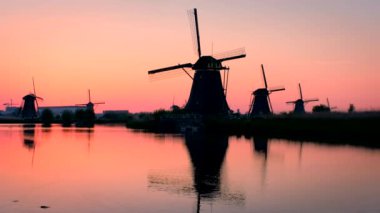 Gün batımında Hollanda 'nın ünlü Kinderdijk turistik bölgesinde dramatik bir gökyüzü bulunan yel değirmenleri. Kinderdijk, Hollanda