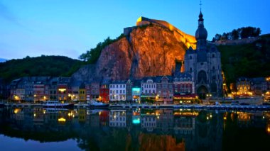 Dinant şehrinin gece manzarası, Meuse Nehri üzerinde aydınlatılmış Dinant Kalesi ve Notre Dame de Dinant Kolej Kilisesi. Belçika