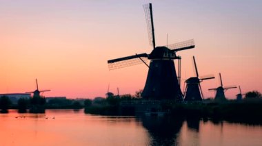 Gün batımında Hollanda 'nın ünlü Kinderdijk turistik bölgesinde dramatik bir gökyüzü bulunan yel değirmenleri. Kinderdijk, Hollanda
