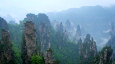 Çin 'in ünlü turistik merkezi - Zhangjiajie taş sütunları Wulingyuan, Hunan, Çin' deki sis bulutları içinde uçurum tepeleri