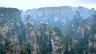 Çin - Zhangjiajie taş ünlü turistik uçurum Dağları sis bulutları Wulingyuan, Hunan, Çin, sütun. Kamera pan ile