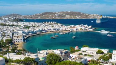 Meşhur yel değirmenleriyle Mykonos şehrinin zaman çizelgesi, tekneleri ve yolcu gemisiyle liman. Mykonos, Cyclades adaları, Yunanistan. Kamera kaydıyla