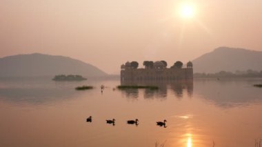Jaipur 'daki ünlü Hint turist şehri Jal Mahal' de (Su Sarayı) sakin bir sabah. Etraftaki ördekler ve kuşlar dingin sabahın tadını çıkarıyorlar. Jaipur, Rajasthan, Hindistan