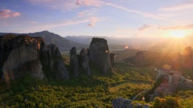 Yunanistan 'ın ünlü Yunan turizm beldesi Meteora' da, Rousanou manastırı ve St. Nicholas Anapavsa Manastırı 'nın üzerinde gün batımı güneş ışınları ve merceklerle parlıyor. Yatay kamera tavası