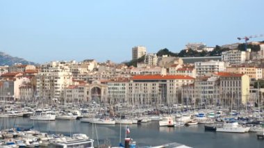 Marsilya Eski Limanı (Vieux-Port de Marseille) yatları ve Notre-Dame de la Garde Bazilikası ile. Marsilya, Fransa. Kamera yansı hareketi