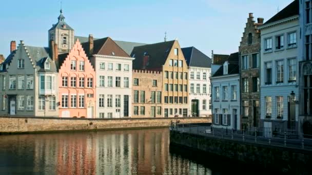 ベルギーの日没時にブルージュの有名な観光都市で古い家や運河 通りを通り過ぎていく車 横のカメラ パンを使って — ストック動画