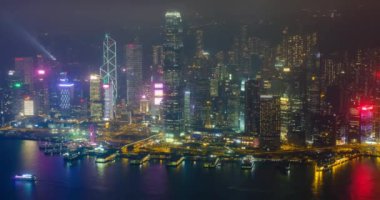 Aydınlatılmış Hong Kong gökdelenlerinin hava zaman çizelgesi şehir merkezindeki gökdelenlerin akşamları. Hong Kong, Çin. Kamera çevirme efekti