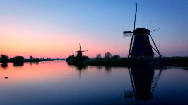 Gün batımında Hollanda 'nın ünlü Kinderdijk turistik bölgesinde dramatik bir gökyüzü bulunan yel değirmenleri. Kinderdijk, Hollanda