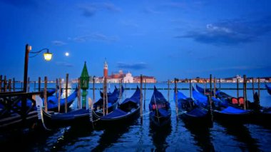 Venedik 'te romantik bir tatil. Saint Mark (San Marco) Meydanı' ndaki Venedik gölünde gondollar. İtalya 'nın Venedik şehrinde akşam üzeri arka planda San Giorgio di Maggiore kilisesi.
