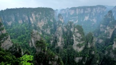 Çin 'in ünlü turistik merkezi - Zhangjiajie taş sütunları Wulingyuan, Hunan, Çin' deki sis bulutları içinde uçurum tepeleri