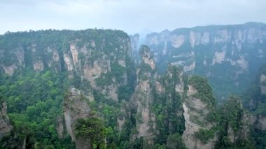 Çin - Zhangjiajie taş ünlü turistik uçurum Dağları sis bulutları Wulingyuan, Hunan, Çin, sütun. Kamera pan ile