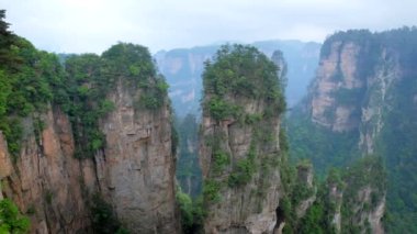 Çin - Zhangjiajie taş ünlü turistik uçurum Dağları sis bulutları Wulingyuan, Hunan, Çin, sütun. Kamera pan ile