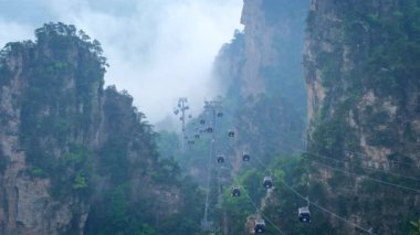Çin - Zhangjiajie taş ünlü turistik uçurum Dağları sis bulutları kablo tren araba Asansör Wulingyuan, Hunan, Çin ile sütun. Kamera pan ile
