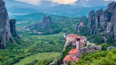 Yunanistan 'ın ünlü turizm beldesi Meteora' da, Rousanou manastırı ve St. Nicholas Anapavsa Manastırı 'nın üzerindeki güneş ışınlarıyla gün batımı zamanı. Uzaklaştırma efekti