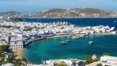 Meşhur yel değirmenleriyle Mykonos şehrinin zaman çizelgesi, tekneleri ve yolcu gemisiyle liman. Mykonos, Cyclades adaları, Yunanistan. Uzaklaştırma efekti