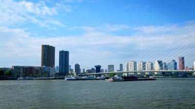 Rotterdam şehir manzarası ve Nieuwe Maas üzerindeki Erasmus köprüsü mavna kargo gemileriyle görünüyor. Rotterdam, Hollanda. Yatay kamera tavası