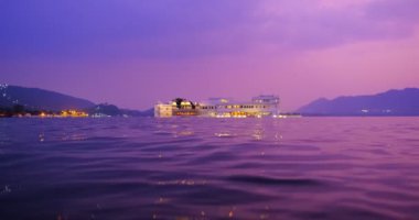 Udaipur Gölü Sarayı 'nın ünlü lüksü, Pichola Gölü' ndeki Jaguar Nivalar, gün batımında su dalgalarıyla aydınlandı. Rajput, Rajasthan 'ın Mewar Hanedanı hükümdarlarının mimarisi. Udaipur, Hindistan