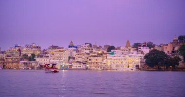 Udaipur Şehir Sarayı, Lal ghat, Pichola Gölü kıyısında evler gün batımında su dalgalarıyla aydınlatılıyor - Mewars 'ın Rajput mimarisi. Udaipur, Rajasthan, Hindistan. Yatay tava