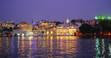Lal ghat: Udaipur haveli, Pichola Gölü kıyısında su tüfekli evler ve ghatlar. Rajput mimarisi. Udaipur 'da gün batımı, Rajasthan, Hindistan.