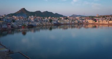 Hindistanın ünlü Hinduizm hac kasabası kutsal Hindu dini şehri Puşkar Brahma mandir tapınağı, göl ve günbatımında geleneksel ghatları olan tepelerin arasında. Rajasthan, Hindistan. Yatay tava