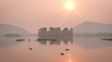 Jaipur 'daki ünlü Hint turist şehri Jal Mahal' de (Su Sarayı) sakin bir sabah. Etraftaki ördekler ve kuşlar dingin sabahın tadını çıkarıyorlar. Jaipur, Rajasthan, Hindistan