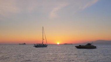 Yunanistan 'ın Mykonos adasında günbatımı, yolcu gemisi ve limanda yatları ve Küçük Venedik' in romantik noktasının renkli rıhtım evleriyle. Mykonos kasabası, Yunanistan