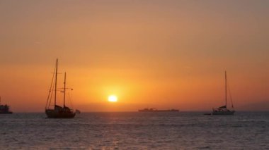 Yunanistan 'ın Mykonos adasında günbatımı, limanda yatlar ve gün batımında Küçük Venedik' in romantik noktasının renkli rıhtım evleri. Mykonos kasabası, Yunanistan. Yatay kamera tavası