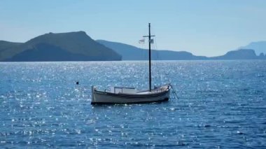 Yunan bayrağıyla Ege Denizi 'nde geleneksel balıkçı teknesi, Milos Adası, Yunanistan