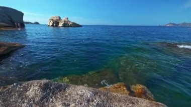 Sarakiniko sahilinin beyaz kaya oluşumları ve Ege Denizi 'nin turkuaz sularındaki yat. Milos Adası, Yunanistan. Yatay kamera tavası.