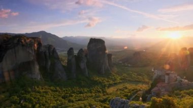 Yunanistan 'ın ünlü Yunan turizm beldesi Meteora' da, Rousanou manastırı ve St. Nicholas Anapavsa Manastırı 'nın üzerinde gün batımı güneş ışınları ve merceklerle parlıyor. Yatay kamera tavası