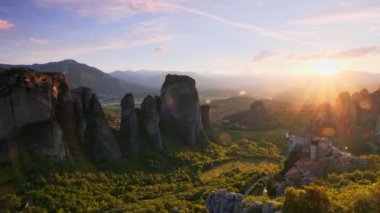 Yunanistan 'ın ünlü Yunan turizm beldesi Meteora' da, Rousanou manastırı ve St. Nicholas Anapavsa Manastırı 'nın üzerinde gün batımı güneş ışınları ve merceklerle parlıyor. Yatay kamera tavası
