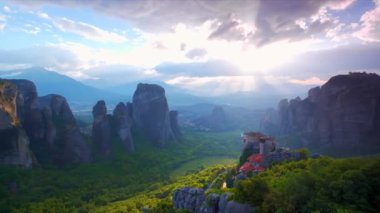 Yunanistan 'ın ünlü turizm beldesi Meteora' da, Rousanou manastırı ve St. Nicholas Anapavsa Manastırı üzerinde güneş ışınlarıyla gün batımı. Yatay kamera tavası