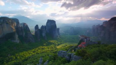 Yunanistan 'ın ünlü turizm beldesi Meteora' da, Rousanou manastırı ve St. Nicholas Anapavsa Manastırı üzerinde güneş ışınlarıyla gün batımı. Yatay kamera tavası