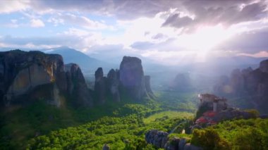 Yunanistan 'ın ünlü turizm beldesi Meteora' da, Rousanou manastırı ve St. Nicholas Anapavsa Manastırı üzerinde güneş ışınlarıyla gün batımı. Yatay kamera tavası