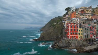 Cinque Terre Ulusal Parkı 'ndaki Riomaggiore köyündeki kayalıklardaki evler UNESCO Dünya Mirası Alanı, Liguria, İtalya. Kamera kaydıyla