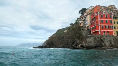 Cinque Terre Ulusal Parkı 'ndaki Riomaggiore köyündeki kayalıklardaki evler UNESCO Dünya Mirası Alanı, Liguria, İtalya. Kamera kaydıyla