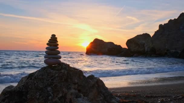 バランスと調和の概念 日没の自然の中で海の海岸に石の小石のキャビンのスタック 石積の瞑想的な芸術 — ストック動画
