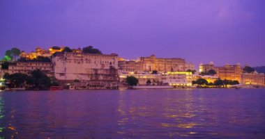 Pichola Gölü kıyısındaki Udaipur Şehir Sarayı 'nın ünlü turizm merkezi gün batımında Mewars' ın Rajput mimarisi ile aydınlandı. Udaipur, Rajasthan, Hindistan