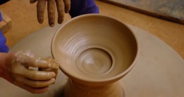 Çömlekçinin becerikli ıslak elleri çömlekçi çarkındaki killeri şekillendiriyor ve vazo yontuyor. Geleneksel el yapımı Hint kasesi, kavanoz, esrar, sürahi üretiyor. Shilpagram, Udaipur, Rajasthan, Hindistan