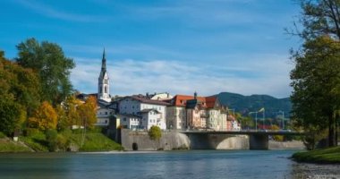 Ünlü turistik kent Bad Tolz 'da altın sonbaharın zamanı. Isar nehrinin manzarası, ağaçlar, kasaba köprüsü, cennet gibi Bavyera evleri ve kilise. Bad Toelz, Bavyera, Almanya. Kamera yakınlaştır