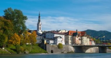 Ünlü turistik kent Bad Tolz 'da altın sonbaharın zamanı. Isar nehrinin manzarası, ağaçlar, kasaba köprüsü, cennet gibi Bavyera evleri ve kilise. Bad Toelz, Bavyera, Almanya. Yatay tava
