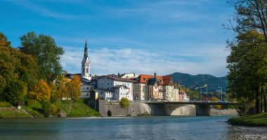 Ünlü turistik kent Bad Tolz 'da altın sonbaharın zamanı. Isar nehrinin manzarası, ağaçlar, kasaba köprüsü, cennet gibi Bavyera evleri ve kilise. Bad Toelz, Bavyera, Almanya.