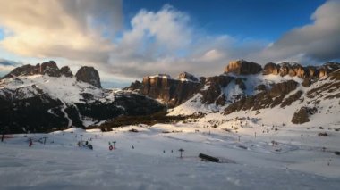 Gün batımında Dolomitler 'de kayak yapan insanlarla dolu bir kayak merkezinin zaman çizelgesi. Kayak alanı Belvedere. Canazei, İtalya