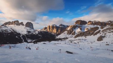 Gün batımında Dolomitler 'de kayak yapan insanlarla dolu bir kayak merkezinin zaman çizelgesi. Kayak alanı Belvedere. Canazei, İtalya