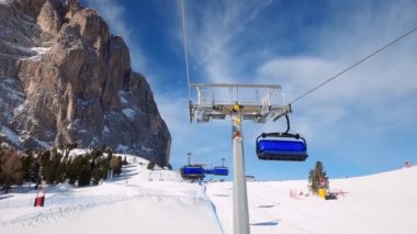 Kablolu sandalyede kayak kaldırmanın FPV bakış açısı Dolomitlerde alp kayağı için yükseliyor. İtalya 'da Dolomitler' de kayak yapan insanlarla kayak merkezi. Kayak alanı Belvedere. Canazei, İtalya
