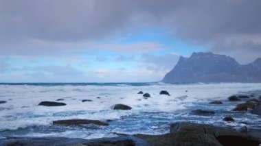 Norveç 'in fiyortlarında kışın karla kaplı kayalar. Utakliev plajı, Lofoten adaları, Norveç. Yatay kamera tavası