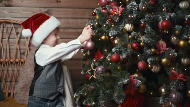 Schattig Jongetje Kerstman Hoed Versieren Van Een Kerstboom Met Kerst — Stockvideo