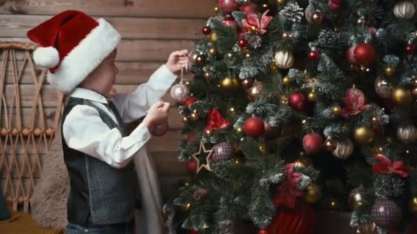 Niño Sombrero Papá Noel Decorando Árbol Navidad Con Adornos Navidad — Vídeo de stock